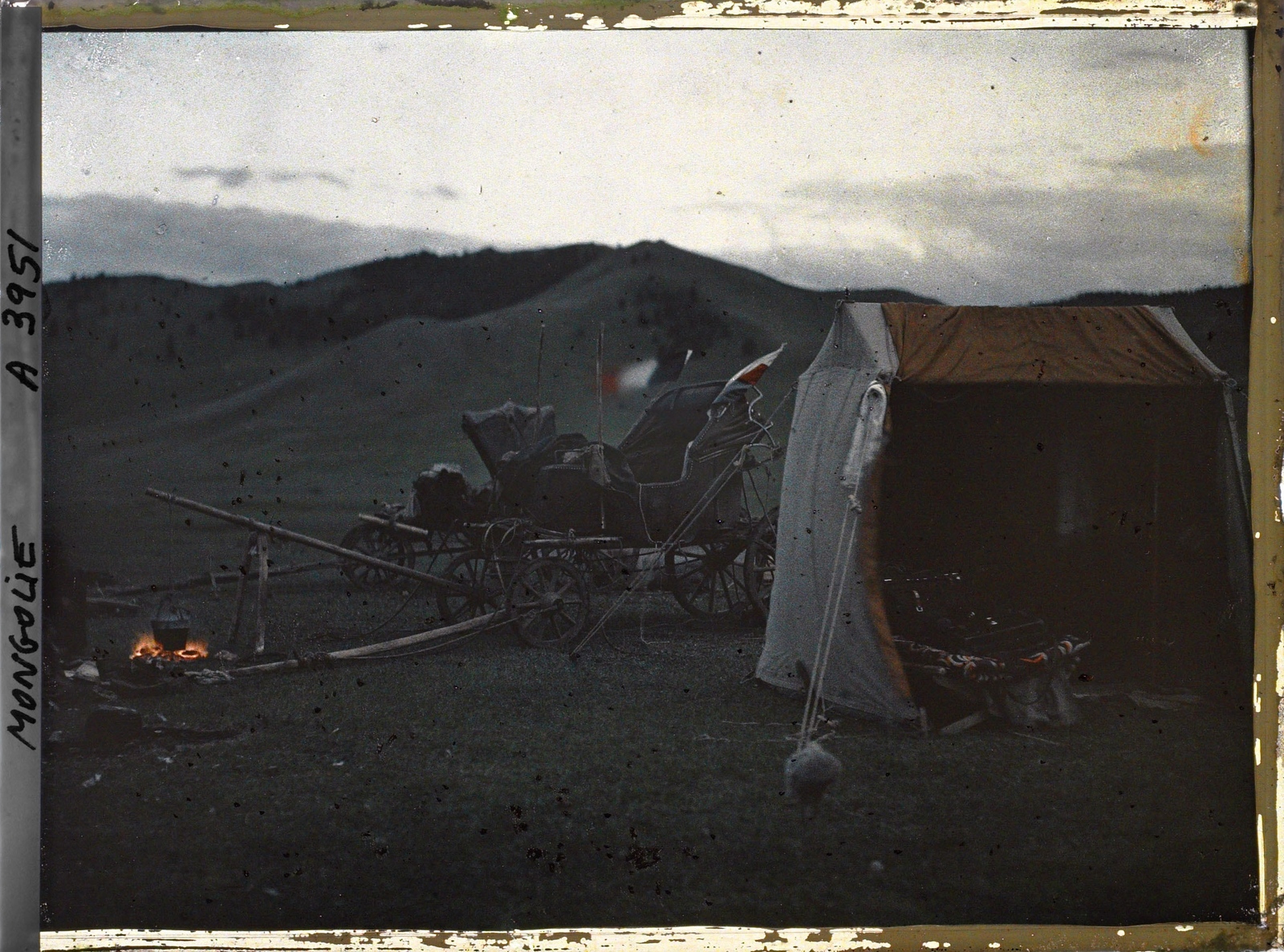 Le tente de l'opérateur et les deux voitures dételées près d'un feu destiné sans doute à la cuisson du repas