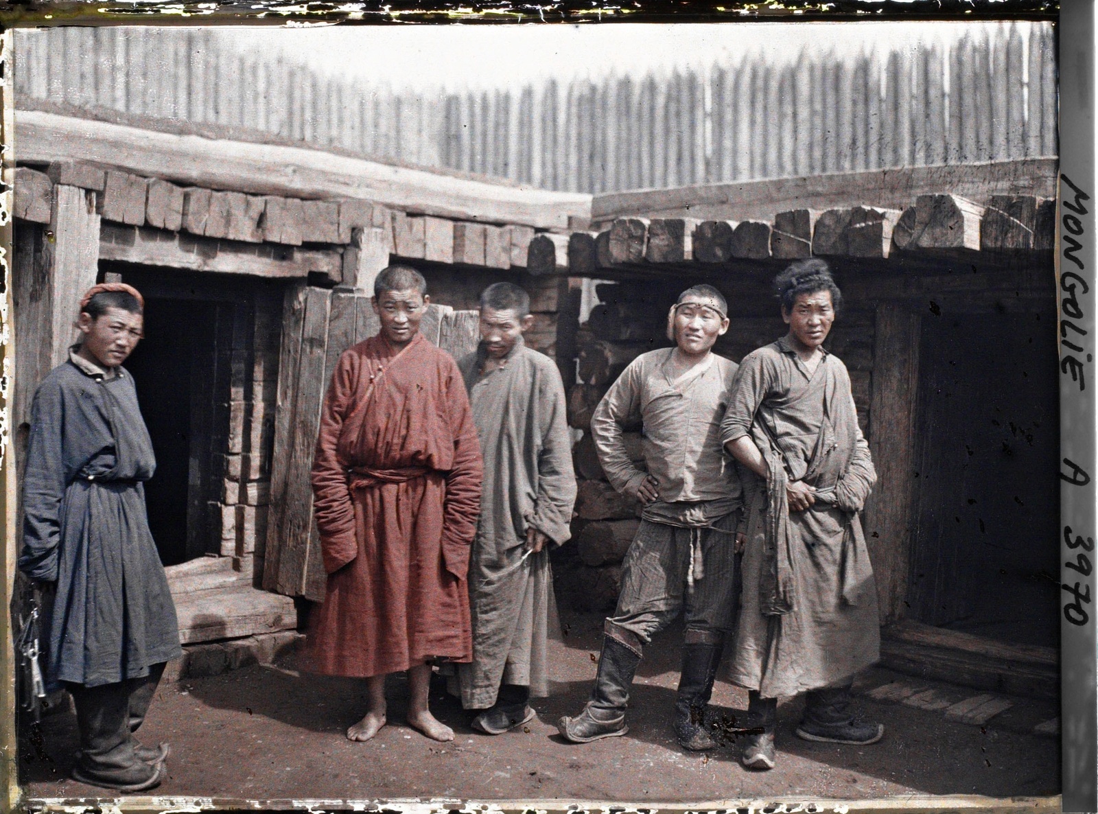 Gardiens, détenus parmi lesquels peut-être un jeune lama près d'une cellule, dans la cour de la prison